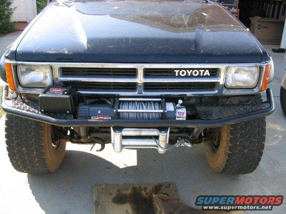 Front view of black Toyota truck with winch and aftermarket bumper. Grille indicates 1989 model