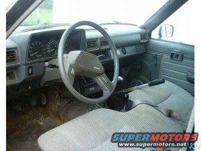 Interior view of a Toyota truck, showing dashboard, steering wheel with Toyota logo, and seats