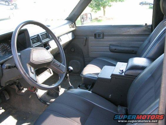 Pickup truck interior with steering wheel, dashboard, seats, and center console