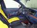 1995 Ford Crown Victoria - The interior of the vehicle features custom yellow and black seat covers and a wood-grain trim on the dashboard.