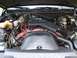 1995 Ford Crown Victoria - The engine bay of a blue 1995 Ford Crown Victoria is shown, the V8 engine and a caution fan shroud.
