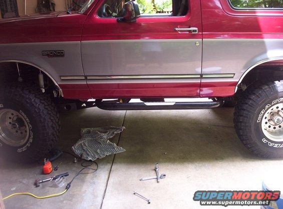 Red and silver Ford Bronco side view, showing running boards and large tires