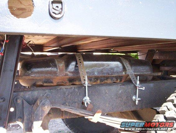 Underbody fuel tank with metal straps and hardware