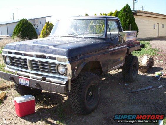 1975 Ford F-Series pickup truck with flatbed, lifted suspension, and off-road tires