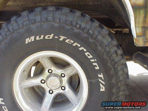 Tire with "Mud-Terrain T/A" text and a five-spoke wheel on a vehicle