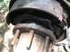 1986 Ford Bronco - Worn brake drum and hub assembly with exposed brake shoes and springs.