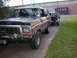 1979 Ford Bronco - This 1979 Ford Bronco is seen from the front 3/4 angle, driving down a road with another vehicle following.