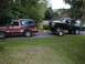 1979 Ford Bronco - Two Ford Broncos are seen side-by-side, with the front vehicle towing the rear vehicle on a trailer.