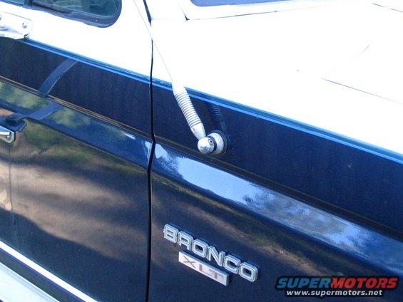 Side view of a blue and white Ford Bronco XLT with a chrome antenna