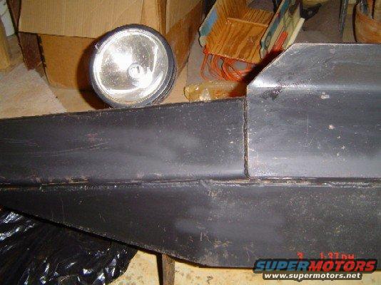 Black bumper section with a round headlight mounted above it