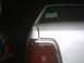 1991 Ford Crown Victoria - Rear view of a silver 1991 Ford Crown Victoria showing a dented quarter panel and a note on the rear window.