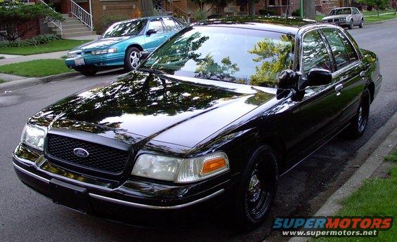 Black 1998 Ford Crown Victoria parked on street, another car behind it