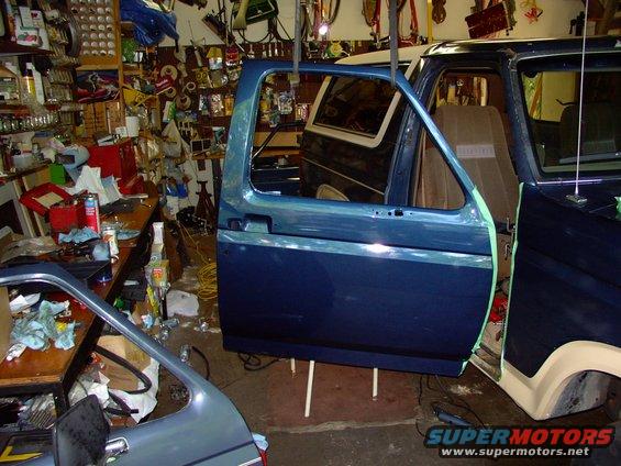 img_0229.jpg Newly painted new door shell hanging by bungees, ready to be bolted onto newly bushed and pinned hinges (see elsewhere).  I had to add two washer to the upper door hinge and "tweak" the upper door to line up the body lines almost perfectly.