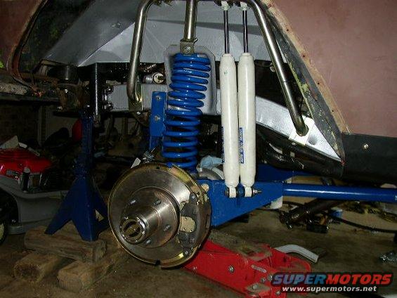 close-up of vehicle's front suspension with blue coilover shocks and brake rotor