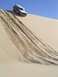 1982 Ford Bronco - A 1982 Ford Bronco navigates a steep sand dune, leaving tracks in the sand.