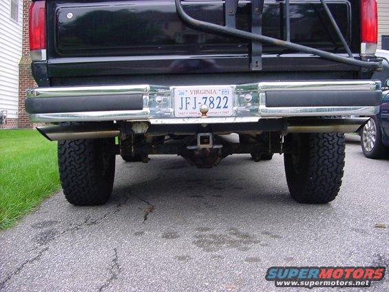 Back of a black pickup truck with a chrome bumper and dual exhaust pipes. Virginia license plate JFJ-7822 is visible