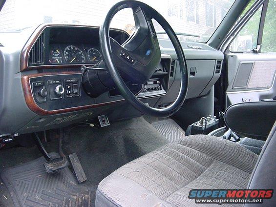 Interior view of a truck's dashboard and passenger seat. Shows gauges, steering wheel, radio, and center console