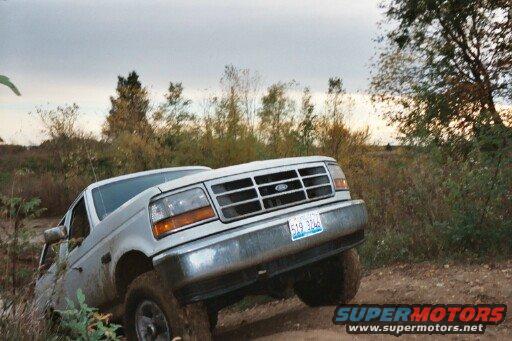 Silver 1992 pickup truck with chrome grille off-roading on dirt path
