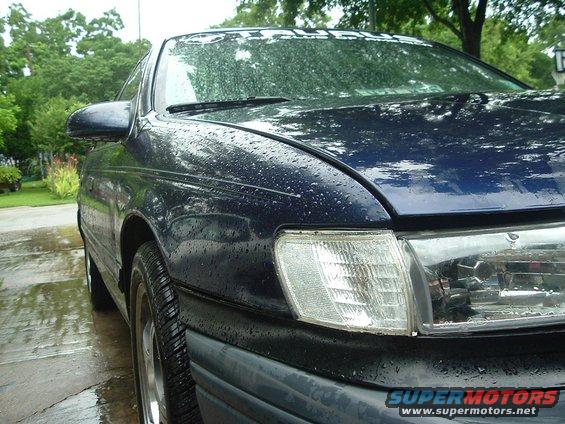 Dark blue 1993 Ford Taurus front passenger side, wet with rain