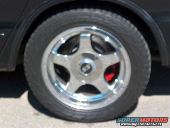 Wheel with chrome five-spoke rim and red brake caliper