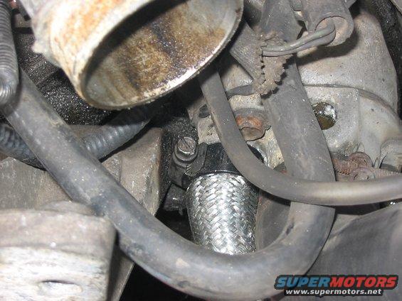 110_1036.jpg close up of the braided elbow hose that goes from the water pump to the front of the starboard bank of the block.  I couldn't use the 7/8's bulk on it because the nipple on the block is larger!!!  it's a 1 inch fitting, yep the hose is special order 7/8's on one side and 1" on the other  so I McGyvered the sucker!!!