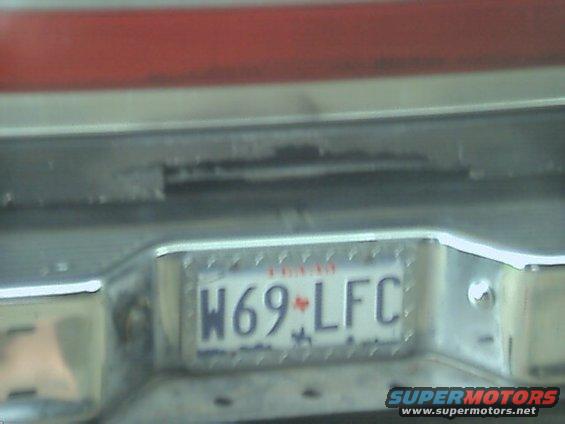 License plate W69-LFC on a chrome bumper, with red paint above