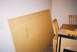 1988 Ford Bronco - A large piece of particle board is propped against a wall in a room with a dining table and chairs.