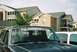 1988 Ford Bronco - A dark gray Ford Bronco is parked in front of apartment buildings, with a white SUV beside it.