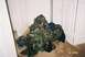 1988 Ford Bronco - Camouflage clothing piled on a carpeted floor near white doors.
