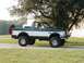 1994 Ford Bronco - This Ford Bronco is a two-tone green and white SUV with a spare tire on the back.