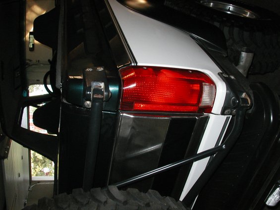 Green and white Ford Bronco rear with spare tire, chrome accents, and aftermarket roll cage