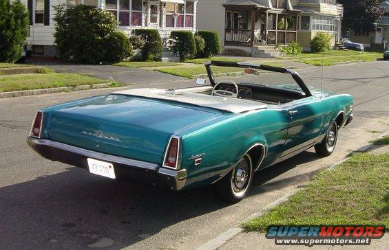 Teal convertible parked on street, rear view. License plate reads 42330