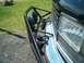 1994 Ford Bronco - The front of a black Ford Bronco is shown with a brush guard and spotlights mounted on the bumper.