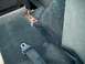 1994 Ford Bronco - The interior of a vehicle shows a black seatbelt and its metal buckle attached to the floor.