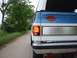 1982 Chevrolet Blazer - The rear of a two-tone Chevrolet K5 Blazer is visible on a dirt road, adorned with a Harley-Davidson emblem.