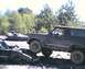 1985 Ford Bronco - A Ford Bronco navigates over a pile of wrecked vehicles in a junkyard or off-road area.