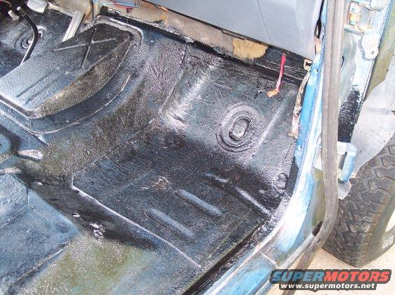 1990 Ford Bronco interior floor with black undercoating and visible pedals