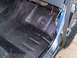 1990 Ford Bronco - The interior floor of a blue vehicle is coated with black bedliner material.