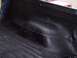 1990 Ford Bronco - The textured surface of a freshly applied truck bedliner is shown, with a red vehicle in the distance.