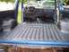 1990 Ford Bronco - Interior view of a blue pickup truck, showing the bedliner and dashboard with exposed wiring.