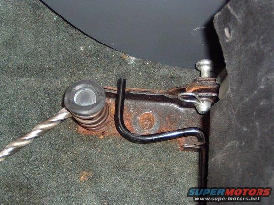 Close-up of a car seat adjustment mechanism with a spring and metal rod