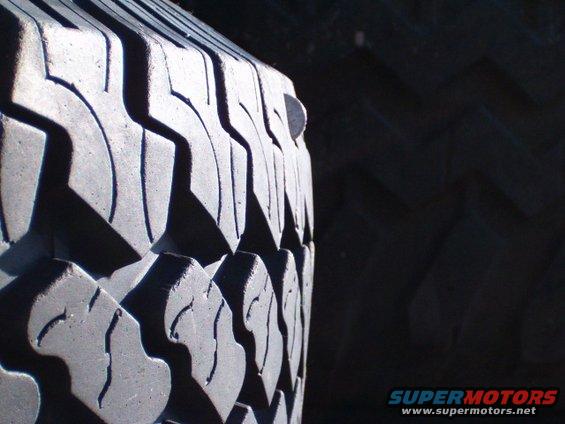 Close-up of a tire tread with a nail in it