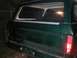 1979 Ford Bronco - The rear of a green SUV is shown, with a close-up of the tailgate and taillight assembly.