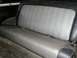 1979 Ford Bronco - The rear bench seat of a vehicle features a textured gray fabric with a striped pattern.