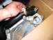 1996 Ford Crown Victoria - A hand is shown adjusting a sensor on a metal engine part, with a black hose and bubble-wrapped components visible.