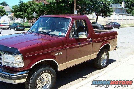 Maroon 1996 Ford Bronco with tan lower body trim parked on a street