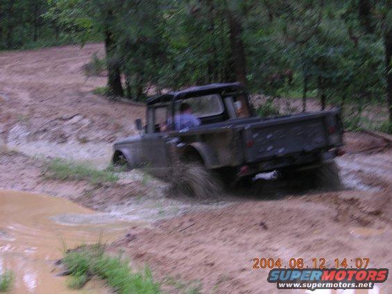 Pickup truck driving through mud, splashing water
