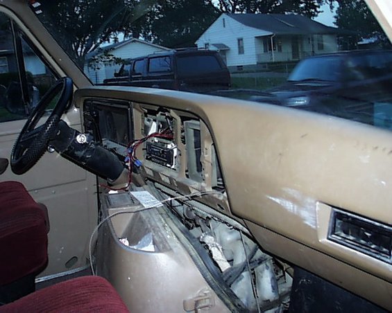 1988 Ford E250 interior with exposed dashboard wiring and maroon seats
