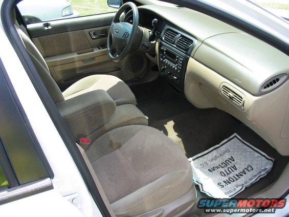 Interior shot of a car, showing front seats, dashboard, and steering wheel. Floor mat says 'Clanton's Auto Auction'