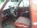 1985 Ford Bronco - The interior of a 1985 Ford Bronco features a brown dashboard, a custom steering wheel, and patterned seats.